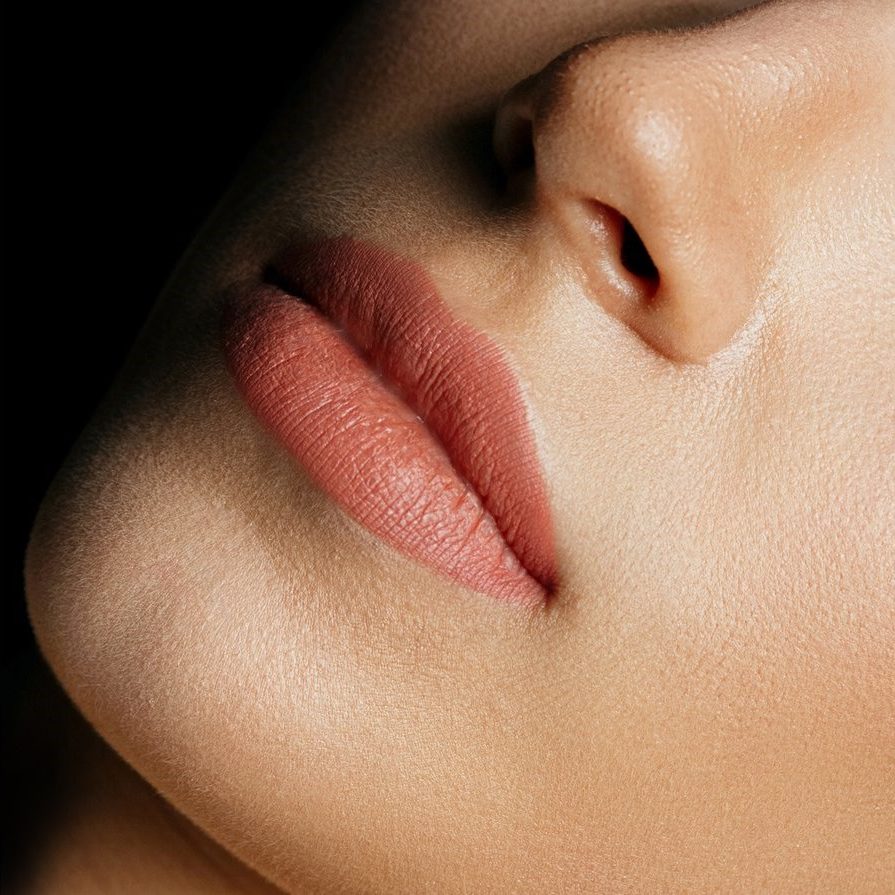 Closeup shot of perfect female lips after permanent makeup procedure. Space for text